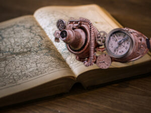 Old hand crafted eye wear with special lenses sitting on an open book displaying an old map.