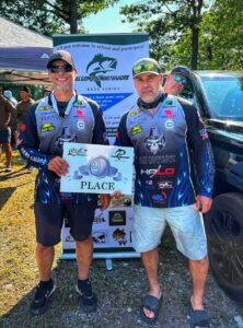 Jeremy and fishing partner Jeff standing and holding the 2nd place plaque for the fishing tournament on Bright Lake.