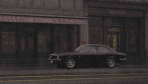 A black 2 door late model sports car parked out in front of some buildings in a typical, older downtown location of a small city with girl standing on the passenger side of the car. It is raining heavy.