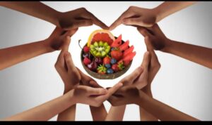 Many hands joined to form a heart around a bowl of food